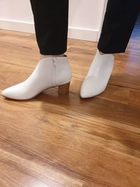 Low section of woman standing on hardwood floor