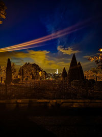 Illuminated buildings against sky at sunset