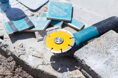 High angle view of circular saw and blue tiles at construction site