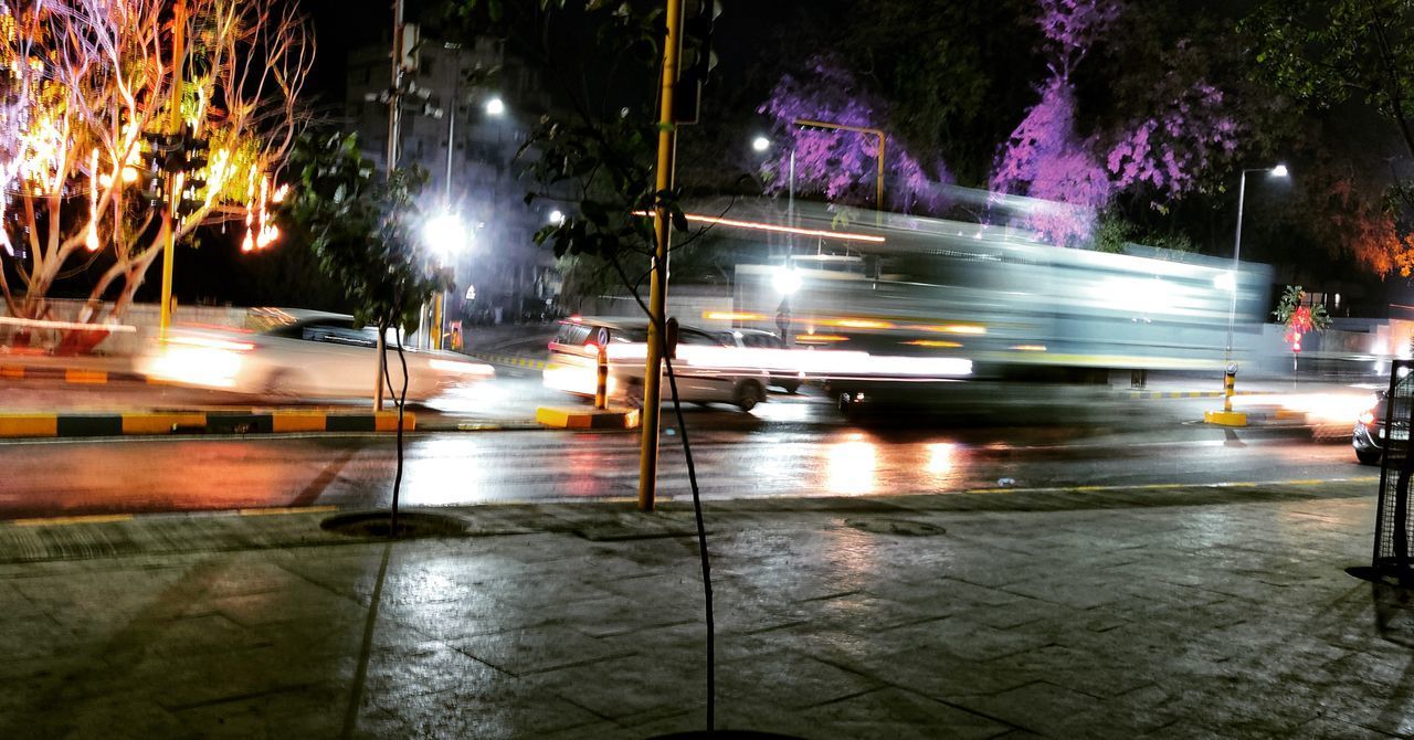 LIGHT TRAILS ON WET STREET DURING RAINY SEASON