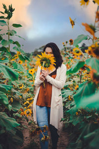 Woman standing on yellow flowering plants