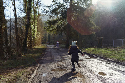 Rear view of girl running on the footpath in forest