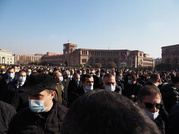 Group of people in town square against sky