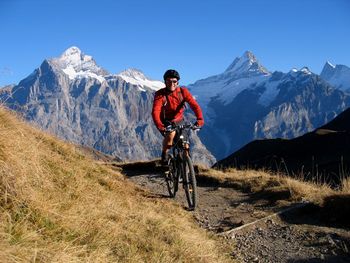 Man riding motorcycle on snowcapped mountain against sky