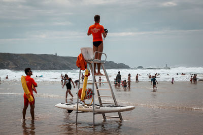 People at beach against sky