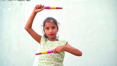 Indian beautiful little girl with garba sticks or dandiya on indian festival navratri.