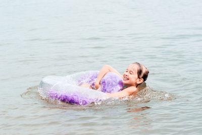 Cheerful girl holding on to an inflatable ring in the river. local tourism. summer vacation