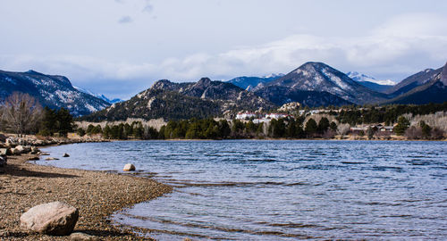 Scenic view of lake by mountains against sky