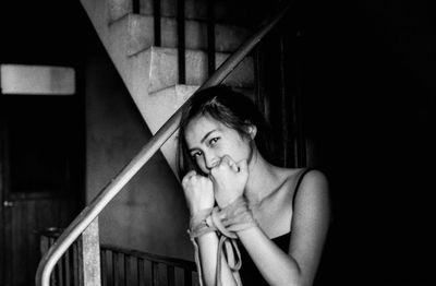 Portrait of young woman with tied hands in darkroom