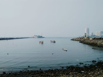 Sailboats in sea against clear sky