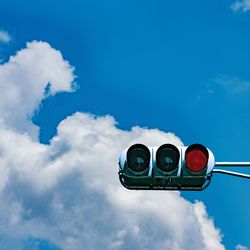 Low angle view of road signal against blue sky