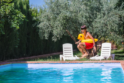 Side view of woman sitting in swimming pool