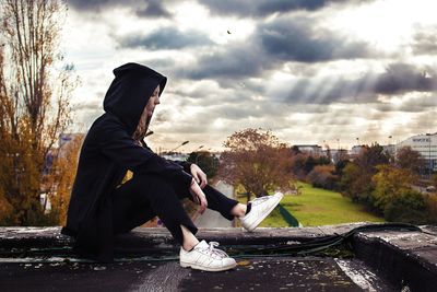 Man sitting on horse cart against sky