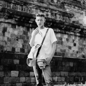 Young man standing against wall