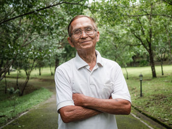 Portrait of smiling man standing against trees
