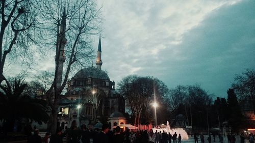 People at town square against sky in city