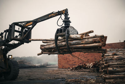 Crane picking up logs at coal factory