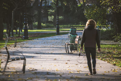 Rear view of woman walking on road