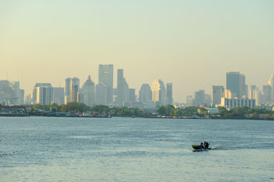 Scenic view of sea and buildings against clear sky