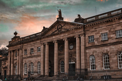 Low angle view of building against cloudy sky