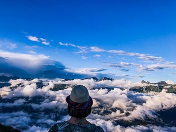 Rear view of woman looking at mountain against sky