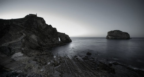 Scenic view of rocks in sea against clear sky