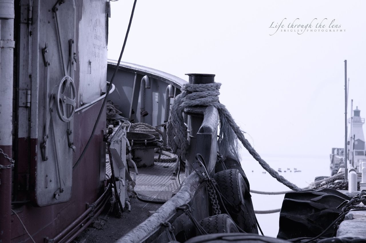 transportation, mode of transport, nautical vessel, boat, moored, clear sky, built structure, building exterior, architecture, land vehicle, obsolete, day, abandoned, car, damaged, travel, old, run-down, outdoors, deterioration