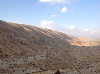 Scenic view of arid landscape against sky