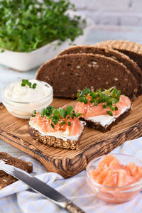 Open sandwich with cheese cream on a slice of rye bread with cereals, slices of marinated salmon 