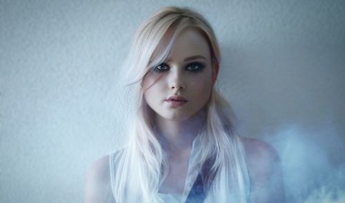 Portrait of young woman against wall