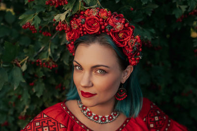 Portrait of young woman standing against plants