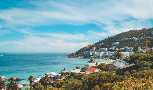 Scenic view of sea by buildings against sky