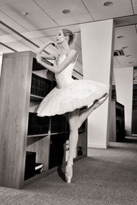 A charming ballerina went to the library to choose a new book during a break