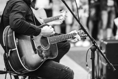 Low section of man playing guitar