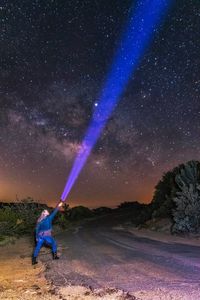 Full length of man standing on field against sky at night