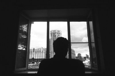 Woman looking through window