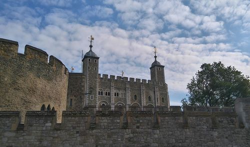 Low angle view of historical building against cloudy sky