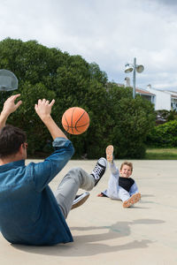 Father and son playing basketball at park