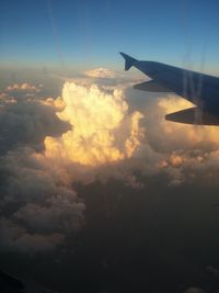 Cropped image of airplane flying over cloudscape