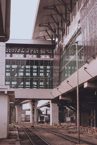 Railroad station platform in city against sky