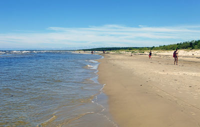 People on beach against sky