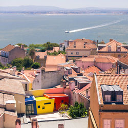 High angle view of houses by sea against sky