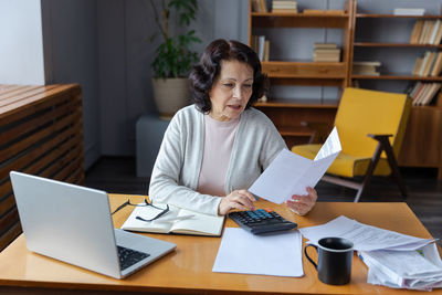 Portrait of man using laptop at office