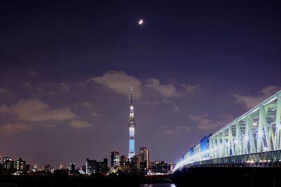 Low angle view of illuminated city against sky at night