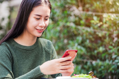 Young woman using mobile phone outdoors