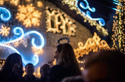 People standing in illuminated city at night