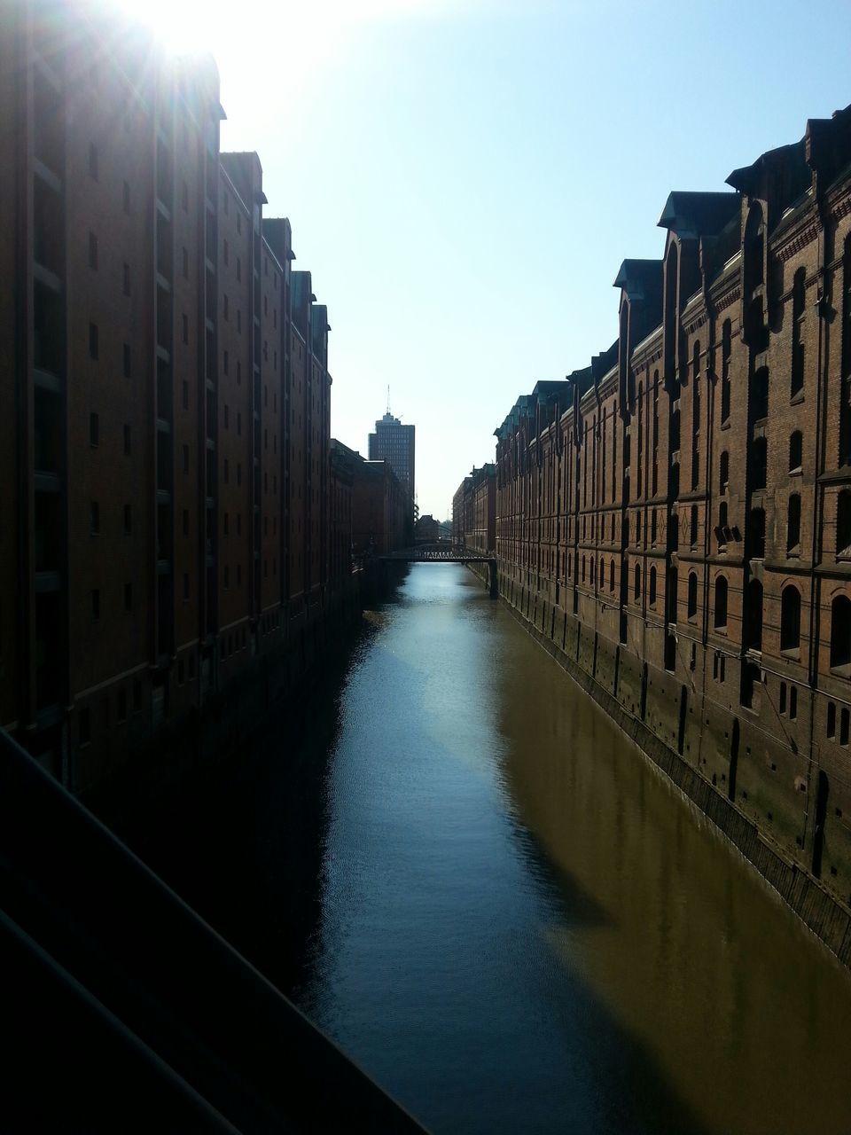 architecture, built structure, building exterior, canal, water, clear sky, diminishing perspective, city, building, waterfront, reflection, residential structure, residential building, river, in a row, sky, the way forward, day, outdoors, vanishing point