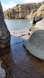 Rock formations by sea against sky