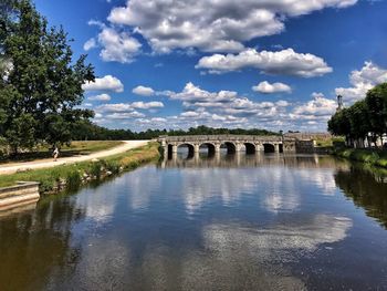 View of bridge over water against cloudy sky