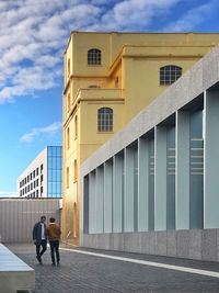 Rear view of people walking on building